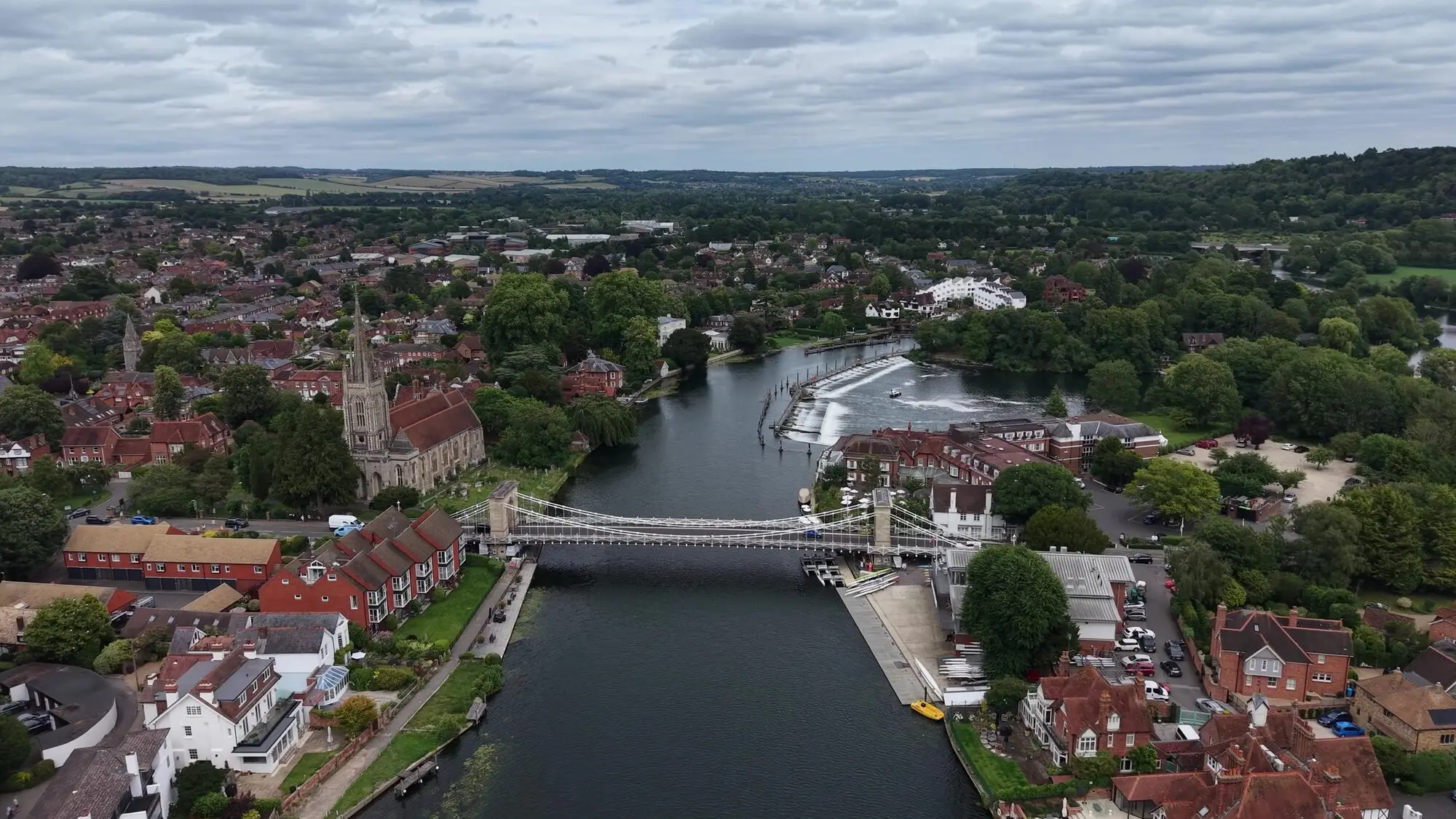 Marlow from above, with the suspension bridge, the weir and All Saints church beside the Thames.