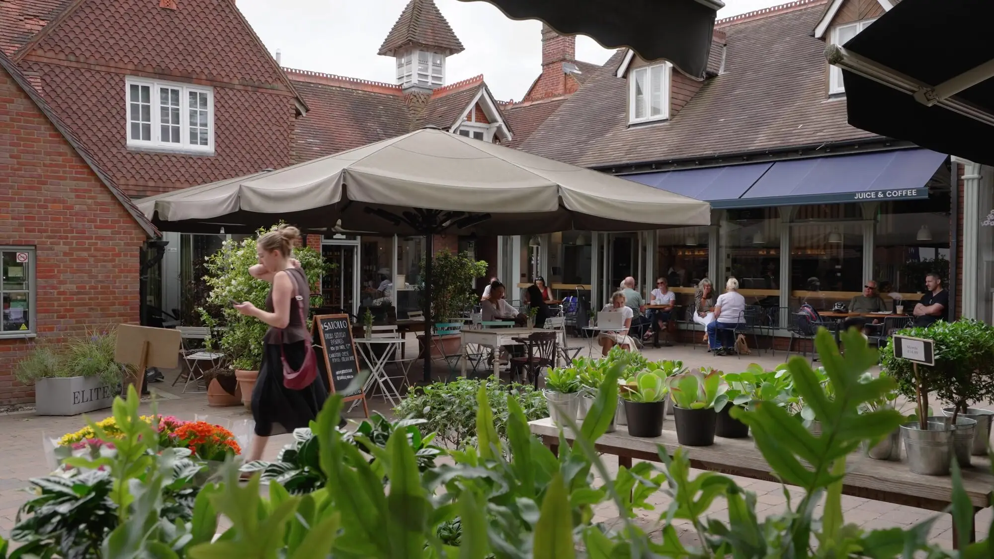 Café terrace in Marlow with tables under parasols and planters.